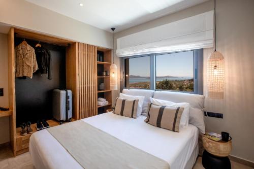 a bedroom with a large white bed with a window at Moncasa Your Ionian home in Kouvaláta