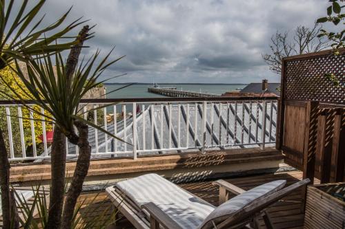 a balcony with chairs and a view of the ocean at The George Hotel and Beach Club in Yarmouth