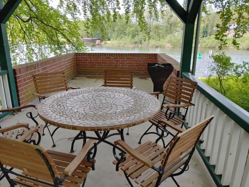 a patio with a table and chairs on a porch at 4 Sterne-Haus am See in Waren
