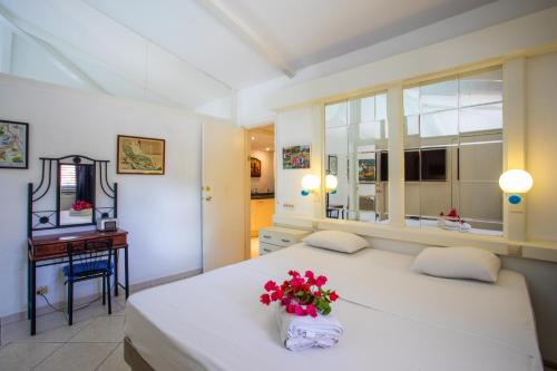 - une chambre avec un grand lit blanc orné de fleurs dans l'établissement Piscadera Bay bungalow Kolibri, à Willemstad