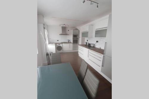 uma cozinha com armários brancos e um balcão azul em Entire House - Cheshire Oaks/Ellesmere Port em Ellesmere Port