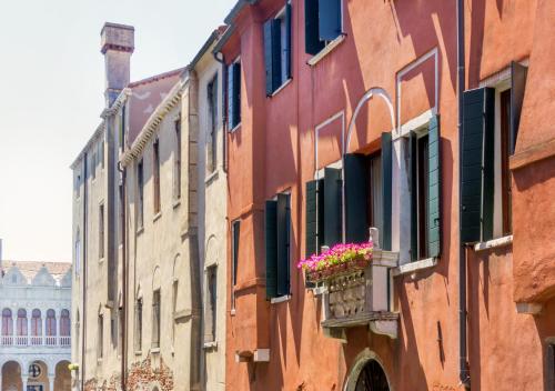 eine Gruppe von Gebäuden mit Blumen auf einem Balkon in der Unterkunft Guesthouse Ca' San Marcuola 1 in Venedig
