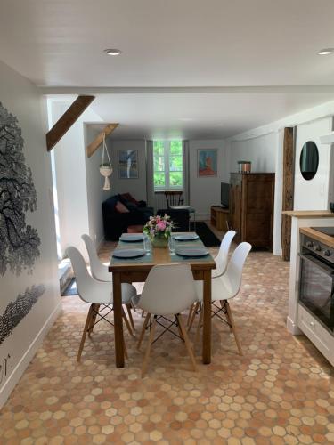 une salle à manger avec une table et des chaises blanches dans l'établissement Le Logis K, le charme au cœur de Saint Pair, à Saint-Pair-sur-Mer