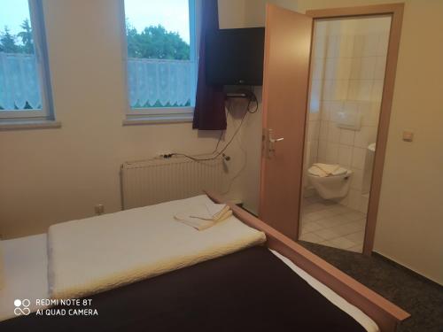 a room with a bed and a bathroom with a toilet at ALTE MOLKEREI Wolgast in Wolgast