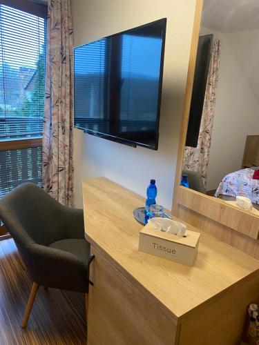 a room with a desk with a television and a chair at ELTAKO penzion in Karlovy Vary