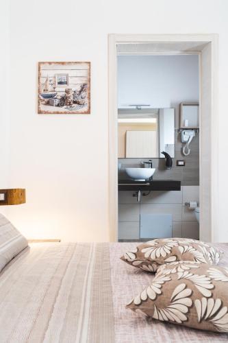 a bedroom with a bed and a bathroom with a sink at B&B Gonare in San Teodoro