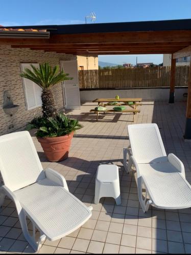 two white chairs and a picnic table on a patio at myrooftop a 10 min dalla Reggia di Caserta in Caserta