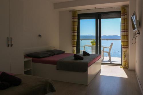 a bedroom with two beds and a view of the ocean at Villa Riki in Živogošće