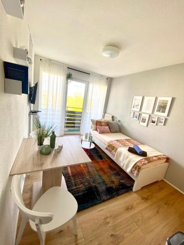 Appartement Universität Mainz في ماينز: غرفة نوم فيها سرير وطاولة فيها