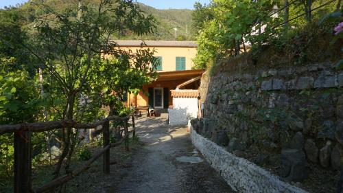 un mur en pierre à côté d'une maison avec une clôture dans l'établissement Agriturismo U muinettu, à La Spezia