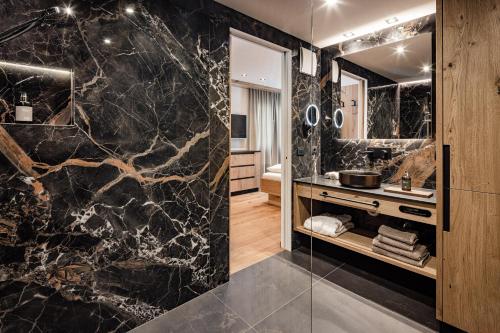 a bathroom with a black marble wall at Apartments Belaval in Santa Cristina in Val Gardena
