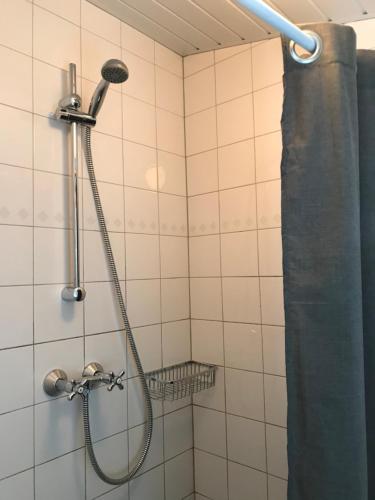 a shower with a shower head and a shower curtain at Zoute Zeelucht in Katwijk aan Zee