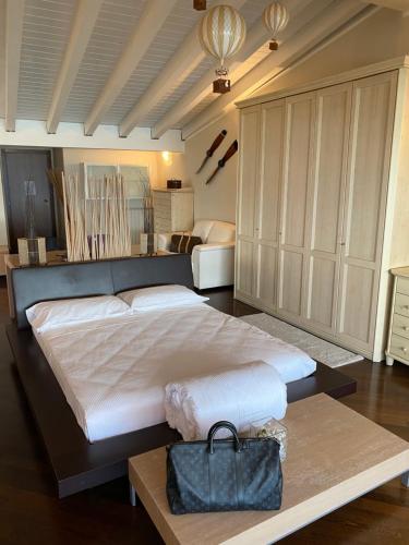 a large bedroom with a large bed with a purse on it at Molino Apartments in Desenzano del Garda