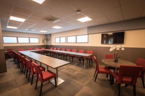 a conference room with tables and chairs and a tv at Hotel Port Toga in Bastia
