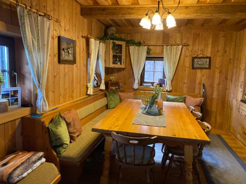 comedor con mesa de madera y sofá en Reinwalds Almhütte en Millstatt