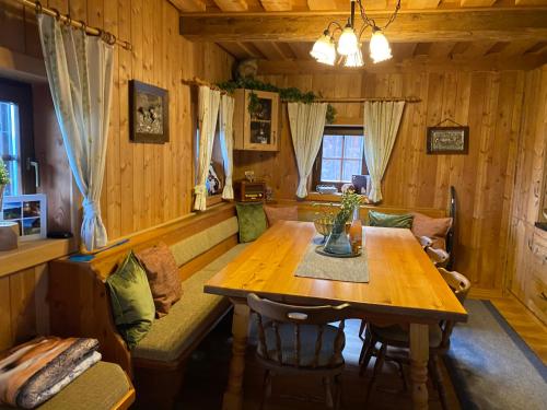 a dining room with a wooden table and a couch at Reinwalds Almhütte in Millstatt