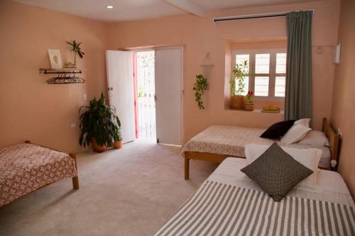 sypialnia z 2 łóżkami i oknem w obiekcie GREAT LOCATION ! 4 Bedroom Home in the Heart of Cartagena w mieście Cartagena de Indias