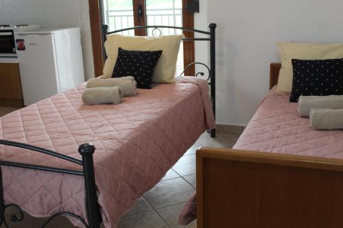 1 dormitorio con 2 camas con sábanas rosas en Vakis Apartments 1, en Romanón