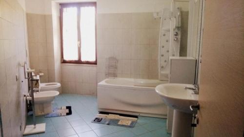 a bathroom with a tub and a toilet and a sink at sette33 in Alghero