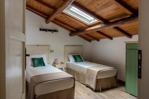 two beds in a room with wooden ceilings at Bed and Box - VT02 Locazione turistica in Viterbo