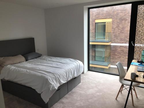 1 dormitorio con cama y ventana grande en Royal Wharf by the Thames en Londres