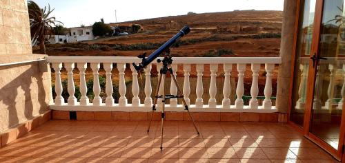 a telescope on a stand on a balcony at Casa las Estrellas in Agua de Bueyes