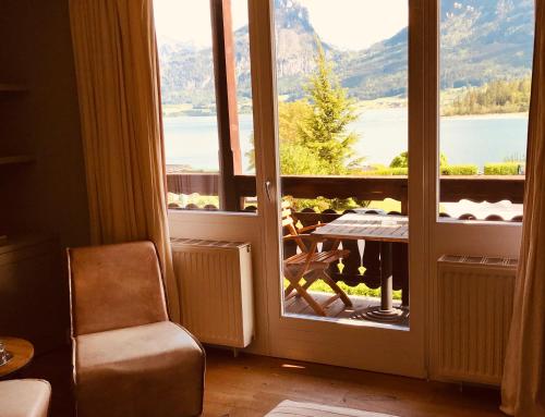 a room with a door to a balcony with a table at Strandhotel Margaretha in St. Wolfgang