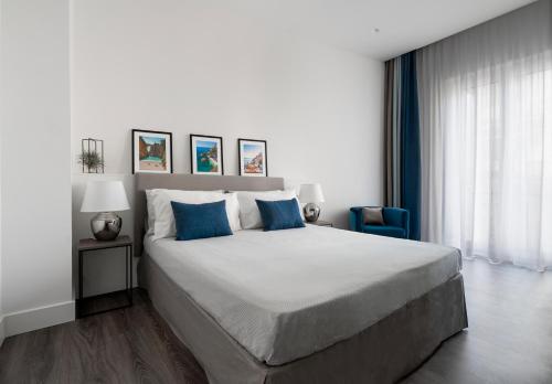 1 dormitorio con 1 cama grande con almohadas azules en Harmony Luxury Rooms, en Castellammare di Stabia