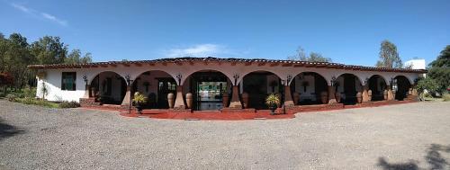 a building with arches and a roof with plants in front at Casa Hacienda Nasca Oasis in Nazca