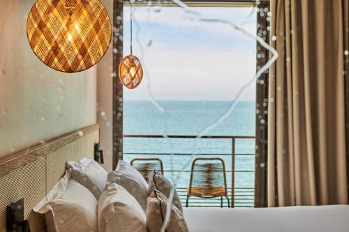 a bedroom with a bed with a view of the ocean at Les Roches Brunes in Collioure