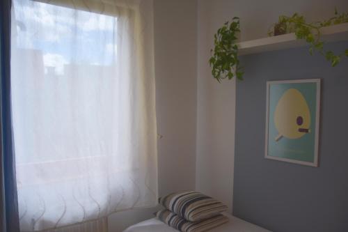 a window with a white curtain and a pillow in a room at STM3 Apartman in Pécs