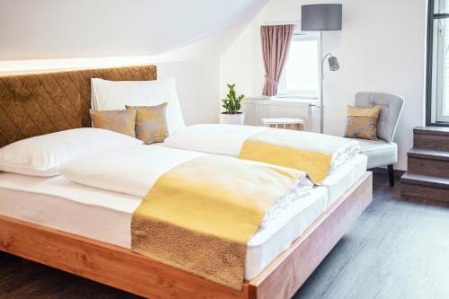 2 Betten in einem Hotelzimmer mit weißen und gelben Decken in der Unterkunft Kollerwirt in Kapfenstein