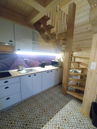 a kitchen with white cabinets and a spiral staircase at Beskidzka Ostoja - Miejsce z duszą in Ustroń