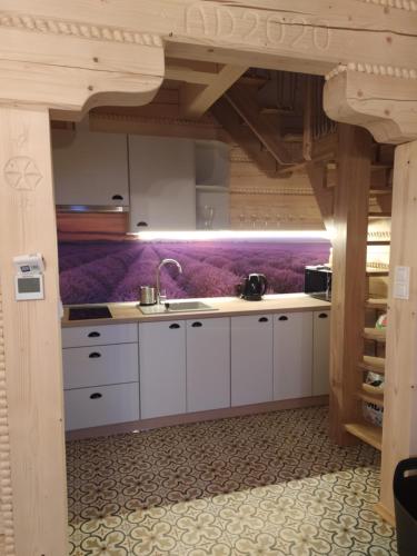 a kitchen with white cabinets and purple walls at Beskidzka Ostoja - Miejsce z duszą in Ustroń