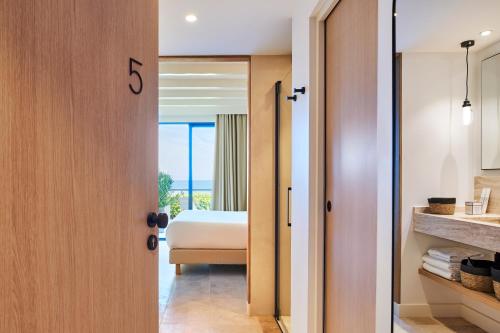 a bedroom with a bed and a bathroom at Les Roches Brunes in Collioure