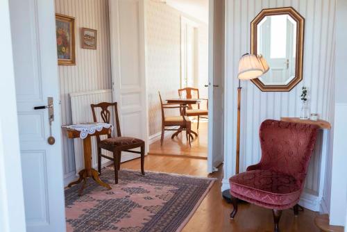 a living room with a chair and a mirror at Prästgårdens Pensionat in Mollösund