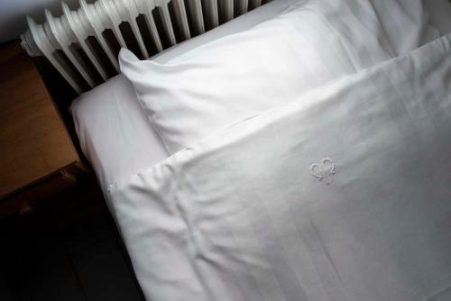 a close up of a white bed with a pillow at Prästgårdens Pensionat in Mollösund