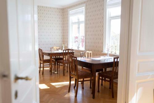 a dining room with a table and chairs and windows at Prästgårdens Pensionat in Mollösund