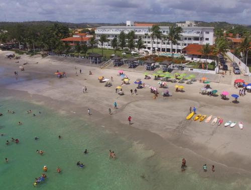 a group of people in the water at a beach at Apart Hotel Marinas Tamandaré in Tamandaré