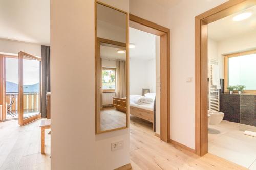a bathroom with a mirror and a bedroom with a bed at Apartment La Brunella in Laion