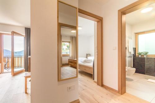 un bagno con specchio e una camera con letto di Apartment La Brunella a Laion