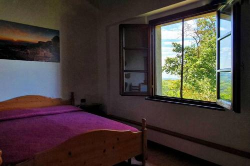 um quarto com uma cama e duas janelas em Appartamento La Rondine em Volterra
