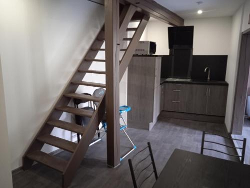 - un escalier en bois dans une cuisine avec une table et des chaises dans l'établissement Au petit dormant, à Saint-Sauveur-en-Puisaye