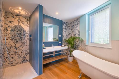 ein Bad mit einer Badewanne und einem großen Fenster in der Unterkunft Plaza Lago di Garda in Peschiera del Garda