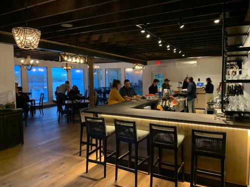 a bar in a restaurant with people sitting at tables at Smuggler's Cove Inn in Boothbay