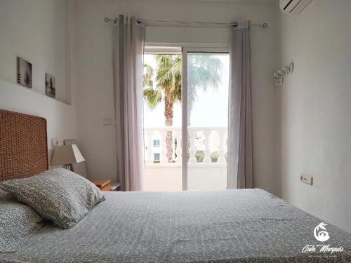 維拉的住宿－Cala Marqués Beach House，一间卧室设有一张床和一个大窗户
