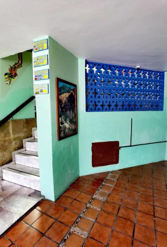 a room with stairs and a blue wall with a painting at The Roof Backpackers in Guadalajara