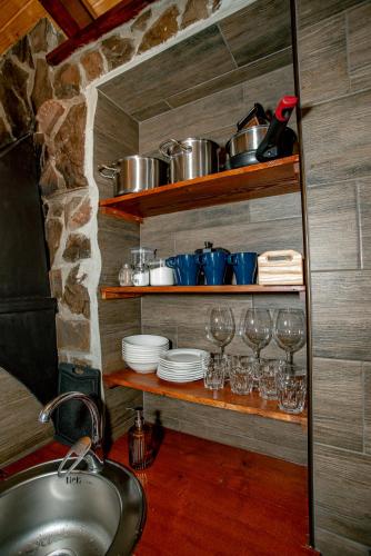 a kitchen with a sink and wine glasses on shelves at Апартаменти Стара Ворохта in Vorokhta