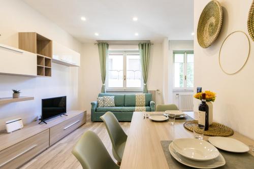 a living room with a table and a green couch at Green Pearl ✰✰✰✰✰ Appartamento a 100 metri dal lago in Arona