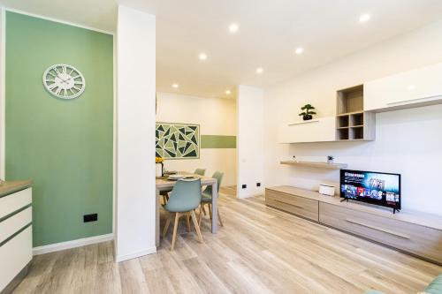 a dining room and living room with a table and a tv at Green Pearl ✰✰✰✰✰ Appartamento a 100 metri dal lago in Arona